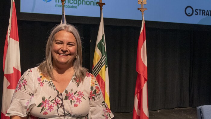 Roxanne Dupuis devant des drapeaux.