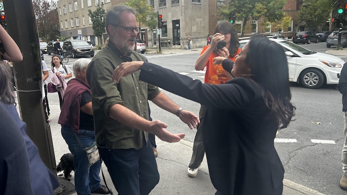 Ruba Ghazal ouvre les bras à son ami sur un trottoir.