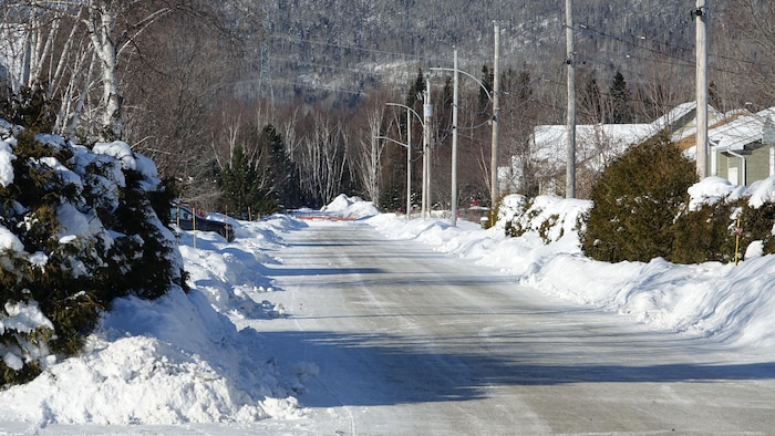 Une rue enneigée avec une route gelée devant une montagne à Maria.