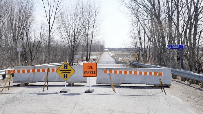 Des barrières et des blocs de béton bloquent une rue.