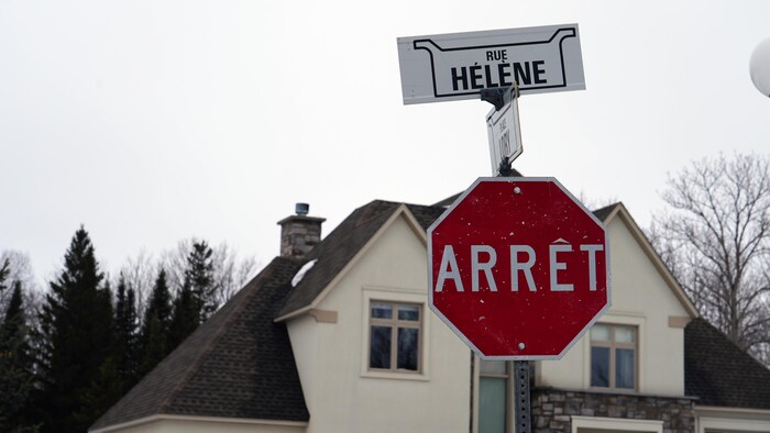 Un panneau de signalisation arrêt, et par-dessus un autre panneau indiquant rue Hélène