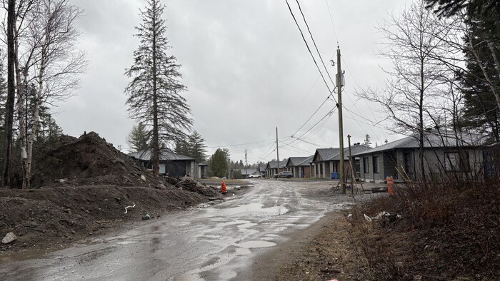 Une route non asphaltée avec des maisons.
