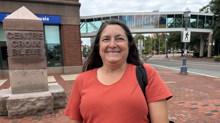 Marie Gallant est debout sur la rue Mechanic avec ses trottoirs de brique rouge. 