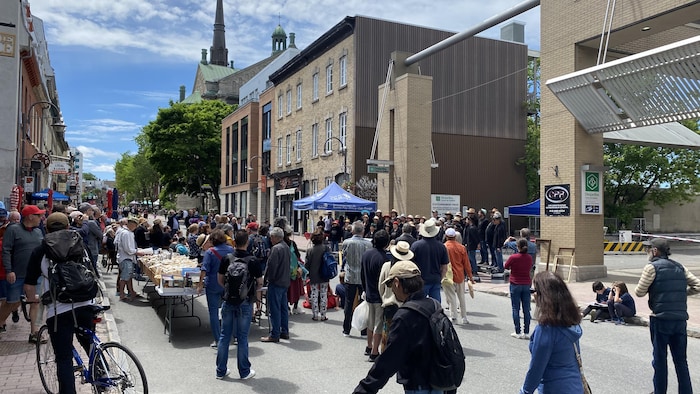 Des citoyens écoutent un spectacle de musique extérieur sur la rue Saint-Jean.