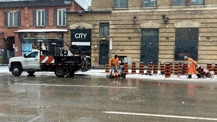 Des travailleurs sont en train de rouvrir une rue à la circulation.