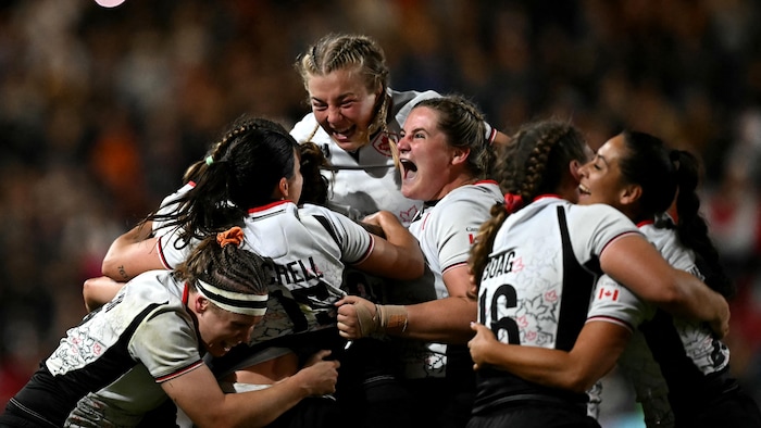 Des joueuses de rugby s'enlacent en fin de match.