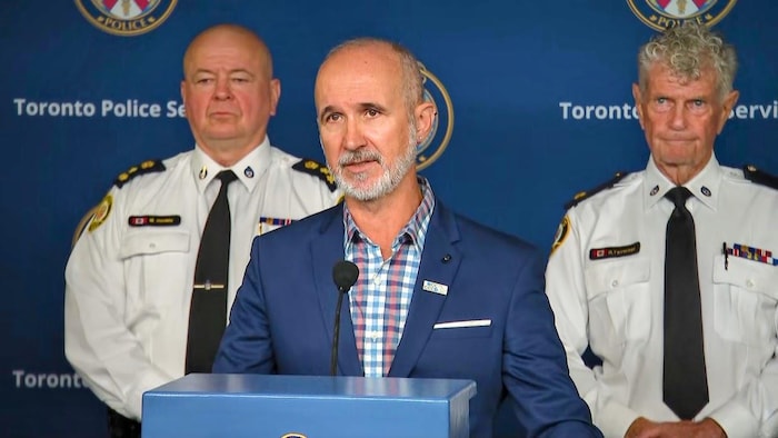 Rui Rodrigues s’adresse aux médias avec Myron Demkiw et Ron Taverner dernière lui.