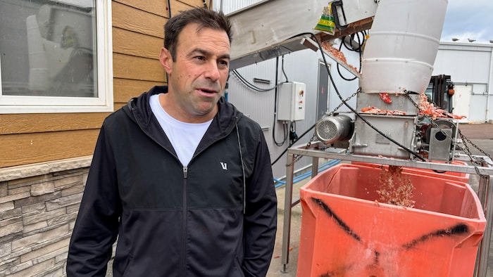 Russel Jacob pose pour la photo à l'extérieur devant de l'équipement de Pêcheries Westmorland.