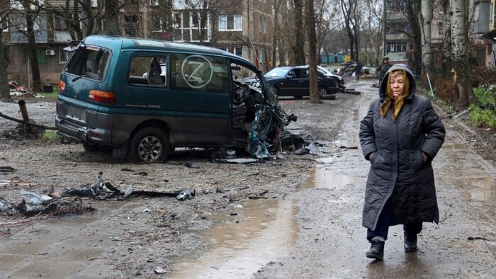 A local resident walks past a damaged vehicle marked with the letter Z, which has become a symbol of the Russian military, in the Ukraine city of Mariupol on April 13, 2022. (Alexei Alexandrov/Associated Press)