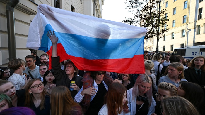 Des partisans tiennent un drapeau russe.