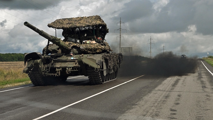 A tank is running on the road. 