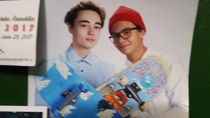 Une photo de deux adolescents avec des skateboards.