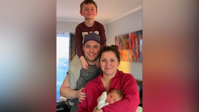 Une photo de famille avec une mère, un père et deux fils.