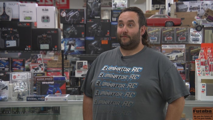 Ryan Gobeil se tient debout dans son magasin.