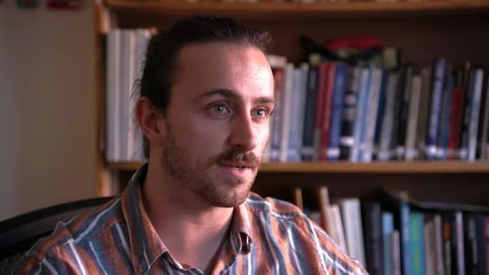 Ryan MacRae en entrevue dans un bureau. 