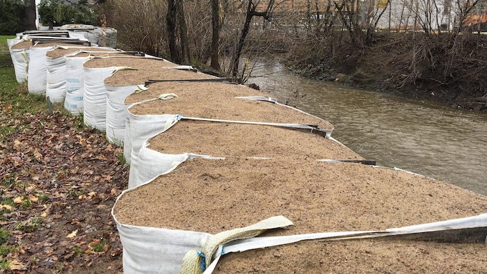Des sacs de sable placés le long de la rivière Lorette.