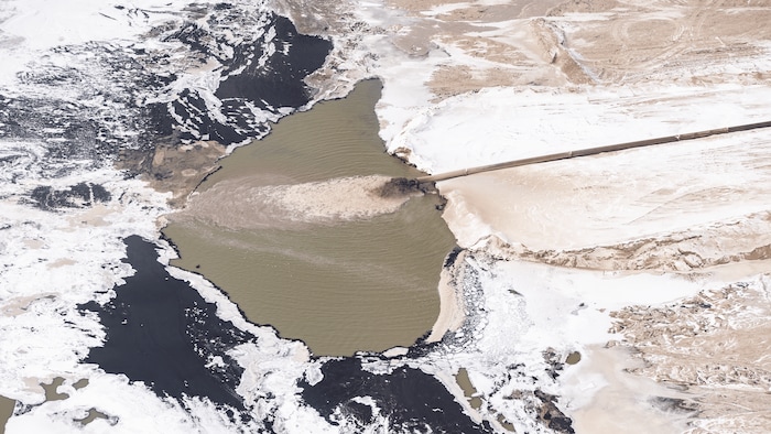 Un tuyau rejette de l'eau brune dans l'environnement.