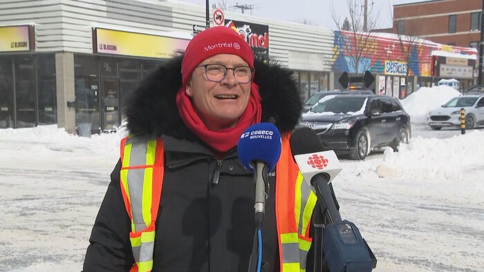 M. Sabourin portant un dossard de sécurité à une intersection.