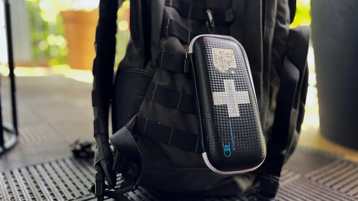 Un sac à dos avec un kit de naloxone attaché à l'extérieur.