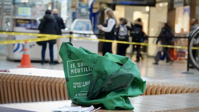 Un sac apparemment souillé de sang sur une table dans un périmètre policier.