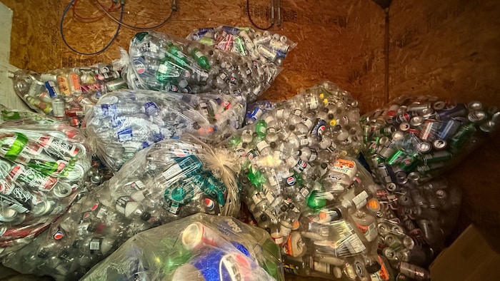 Des sacs contenant des bouteilles et des canettes consignées