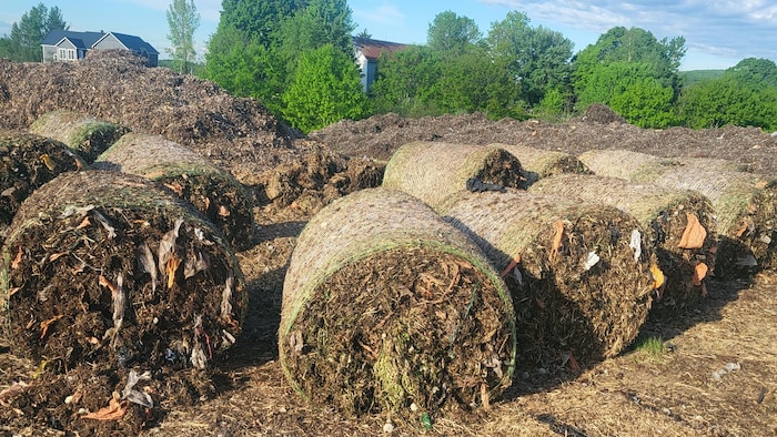 Des ballots de feuilles mortes broyées contaminés par des résidus de sacs de plastique. 