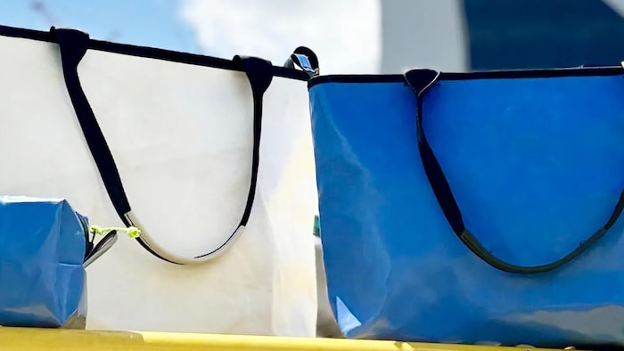Un sac blanc, ainsi qu'une trousse et un sac bleus devant le stade.