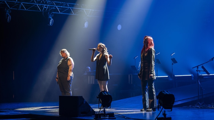 Ariane Roy chante sur scène entourée de Safia Nolin et Lou-Adriane Cassidy.