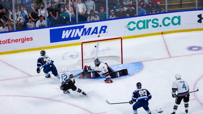 Un joueur marque un but au hockey. 
