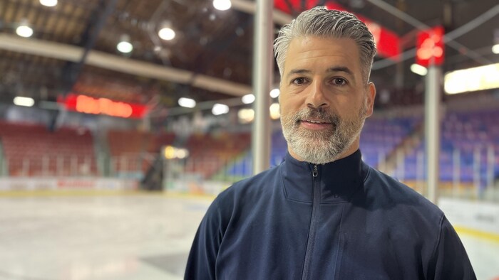 Yanick Jean pose devant la patinoire.