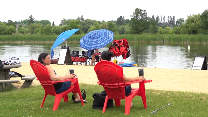 Deux personnes assises face a la riviere Winnipeg.