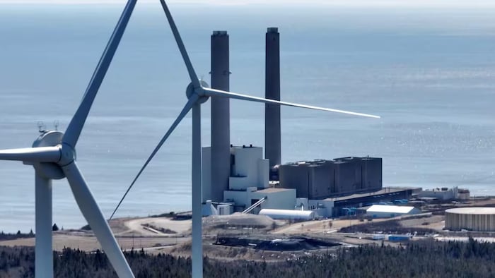 Deux éoliennes, avec la centrale en arrière-plan.