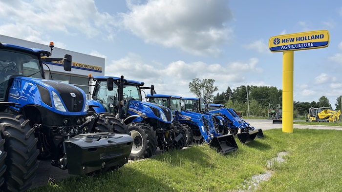 Des tracteurs devant un garage.