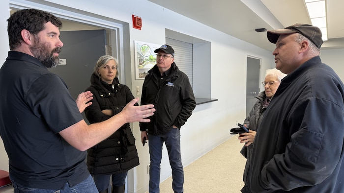 Cinq personnes discutent dans une salle.
