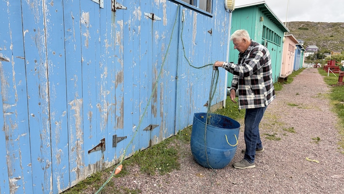 Un homme est en train de réparer son filet de pêche.