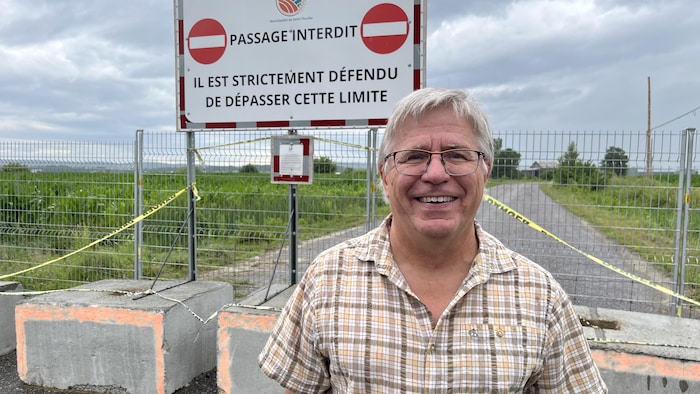 "passage interdit. Il est strictement défendu de dépasser cette limite." Une haute clôture et des blocs de béton empêchent de circuler plus loin sur la route.