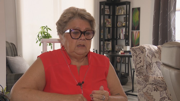 Une femme parle devant la caméra.