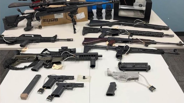 Des armes diverses sont placées sur des tables. 