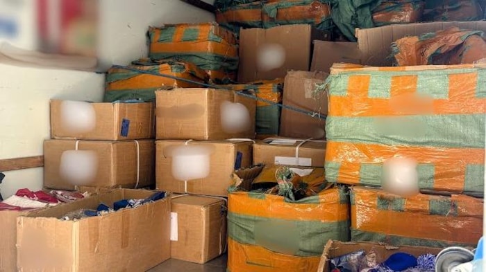 Les objets saisis sont emballés dans des boîtes dans une unité d’entreposage.