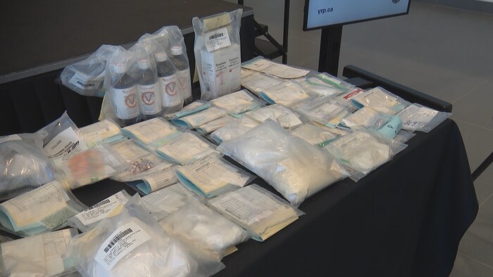 Des pochettes en plastique sur une table qui laissent deviner des substances illicites dedans.
