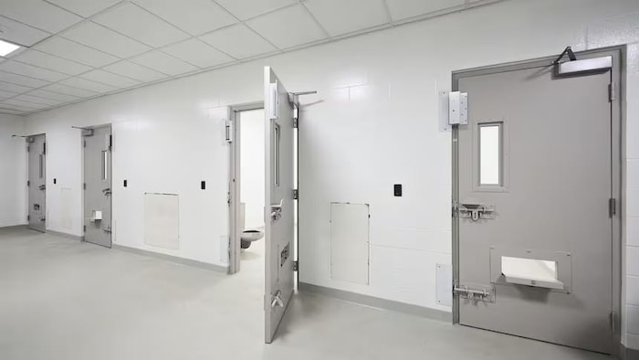 Une porte ouverte qui dévoile une petite salle qui comporte une toilette.