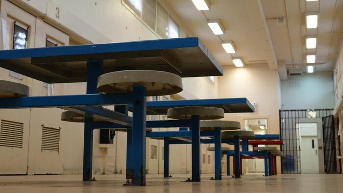 Tables and stools in a common area in a detention centre.