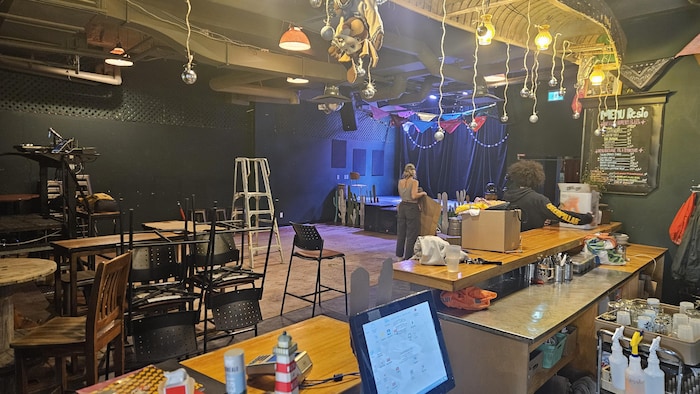 Des personnes font du ménage dans une salle de spectacle.