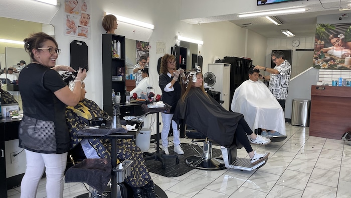 Des clients se font teindre et couper les cheveux dans un salon de coiffure.