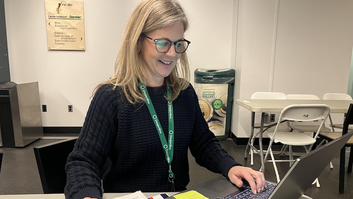 Sylvie Tremblay consulte son ordinateur portable en souriant.