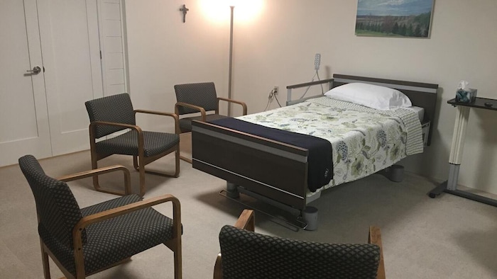 Un lit entouré de chaises dans une pièce.