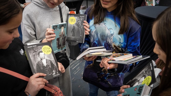 Des jeunes qui tiennent des livres.
