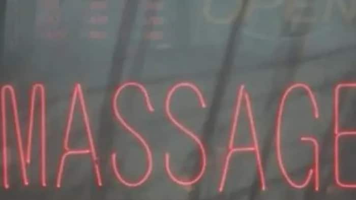 Gros plan sur la fenêtre d'un salon de massage où il est écrit «massage».