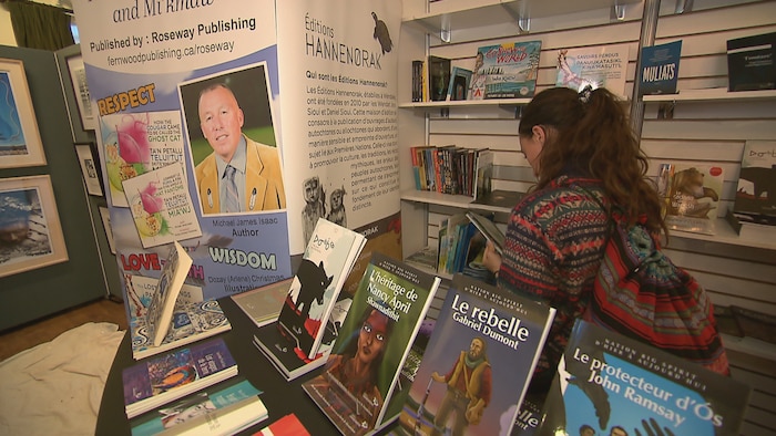 Une femme de dos lit un livre au Salon  du livre des Premi&egrave;res Nations.