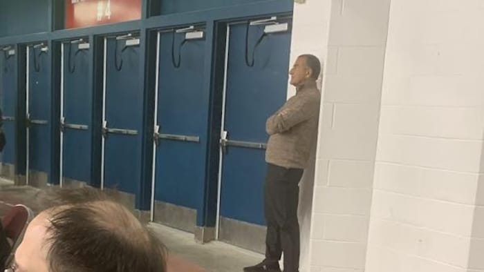 Homme accoté sur un mur dans l'aréna.